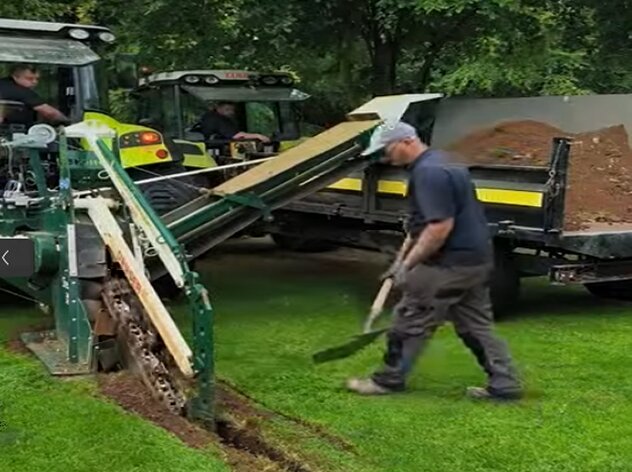 A narrow bucket trencher installing a drain
