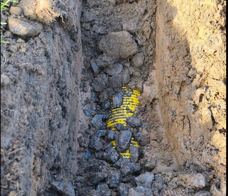 Water flowing from a trial pit, confirming an existing drain is functioning
