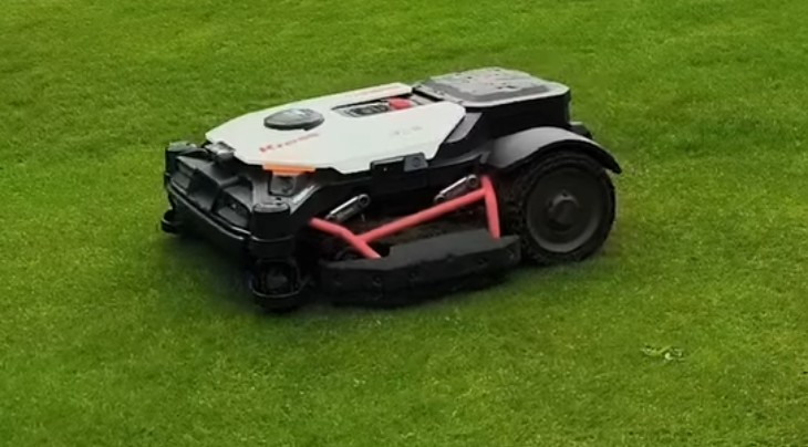 A white Kress robotic mower cutting a golf course fairway